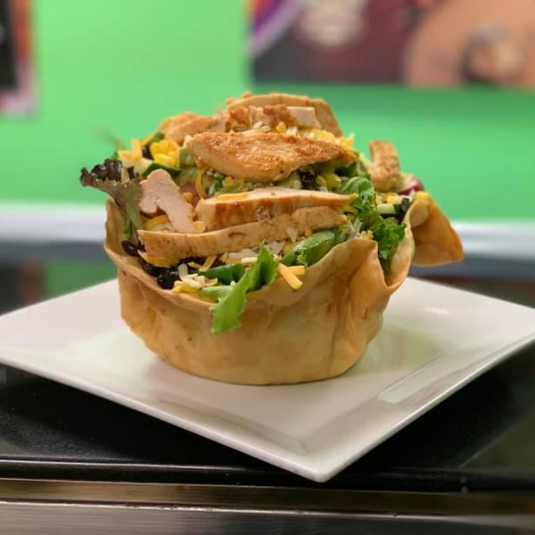 Benji's Taqueria Mexican Grill's taco salad with chicken, lettuce, cheese, and black beans in a crispy tortilla bowl.